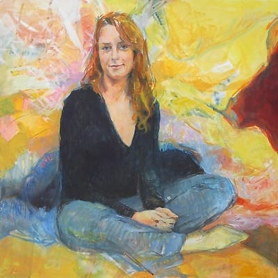 Young woman with long red hair, in lotus position against a colorful background.
