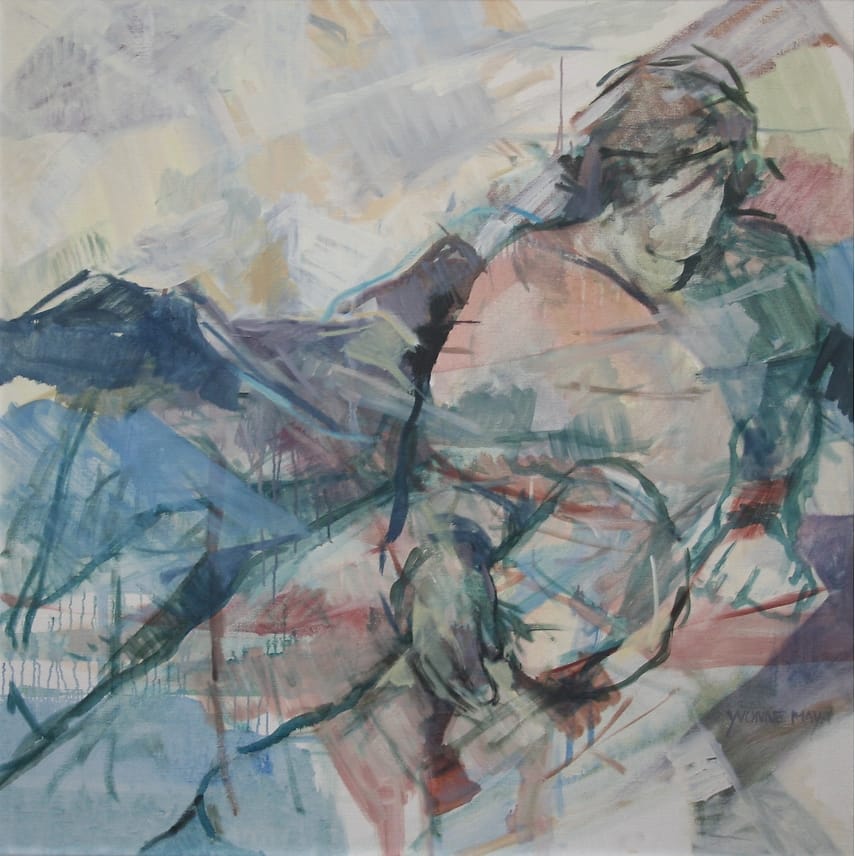 Young man with one of his legs pulled up resting on a bed.